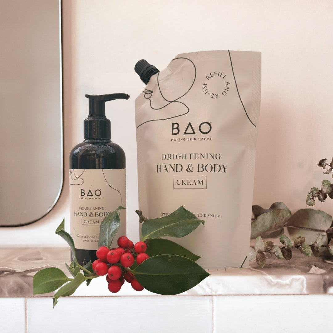 BAO brightening hand and body cream bottle and packaging with green leaves and berries on a neutral background