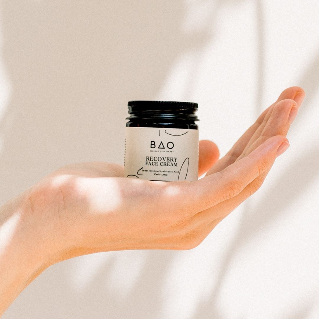 BAO Recovery Face Cream jar held open-palm against a sunlit backdrop
