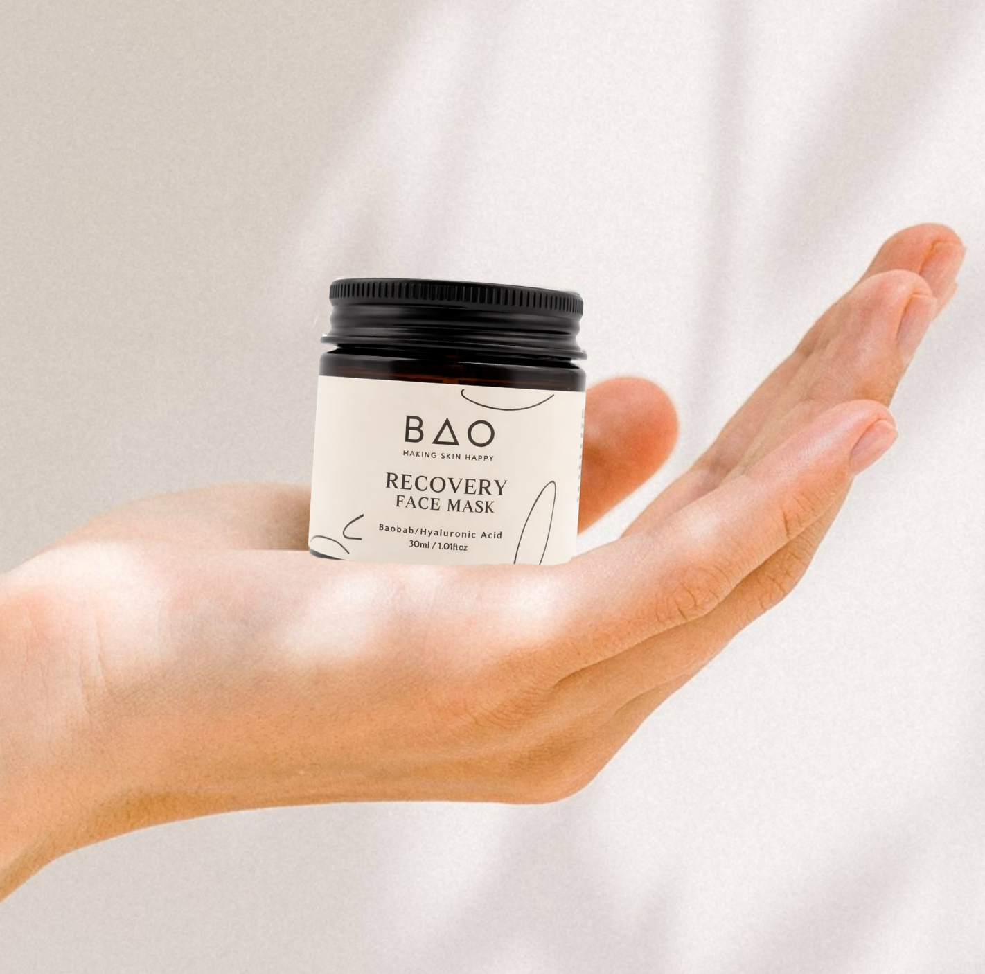BAO Recovery Face Mask jar held open-palm against a sunlit backdrop