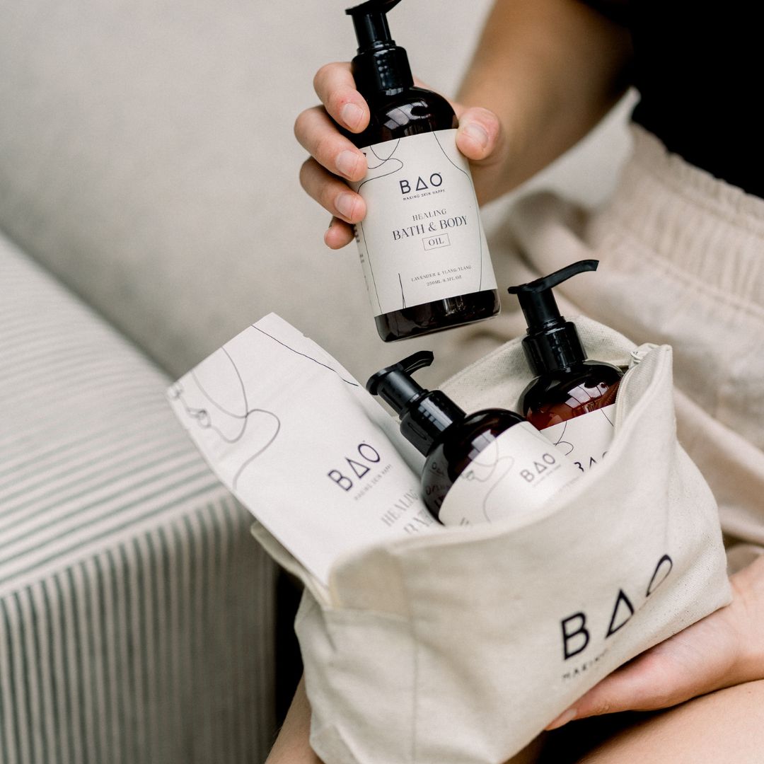 Hands packing BAO Brightening Hand & Body Wash and Cream bottles into the BAO canvas gift bag