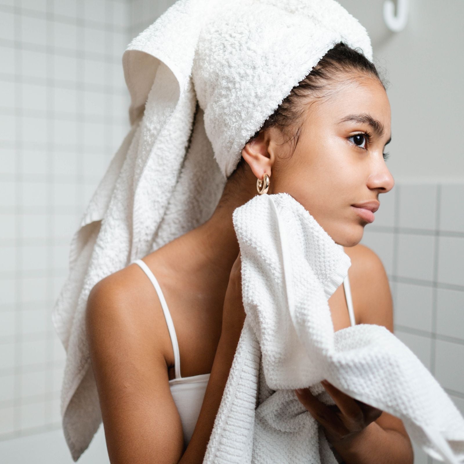 Woman drying her face after her evening skincare routine.