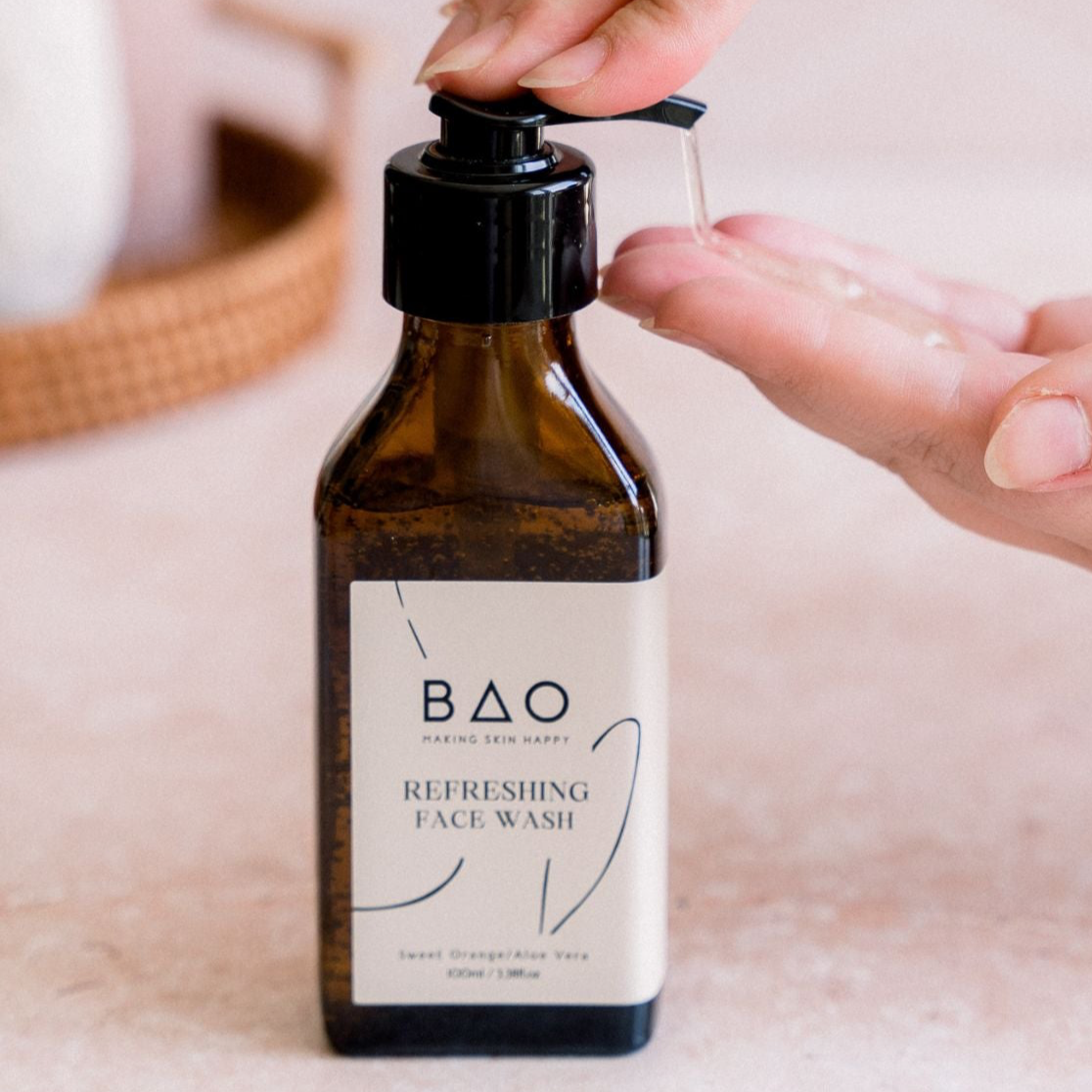 Brown bottle of BAO Refreshing Face Wash with a pump being used.