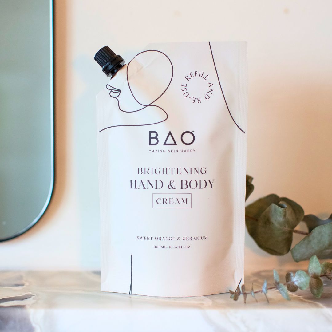 BAO Brightening Hand & Body Cream refill pouch standing on a bathroom shelf with eucalyptus