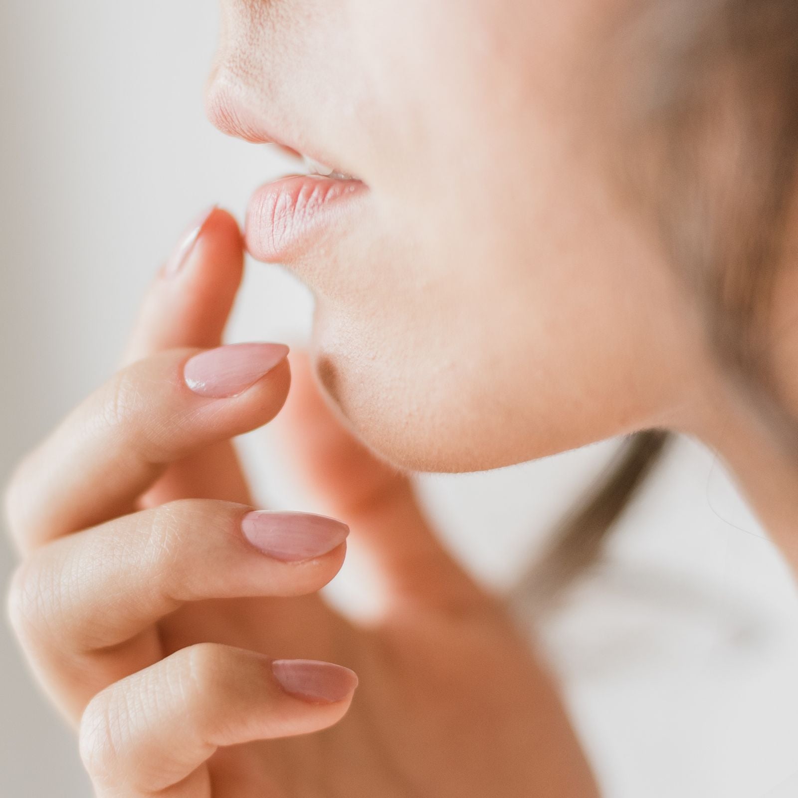 Woman putting natural and vegan saviour balm onto dry lips