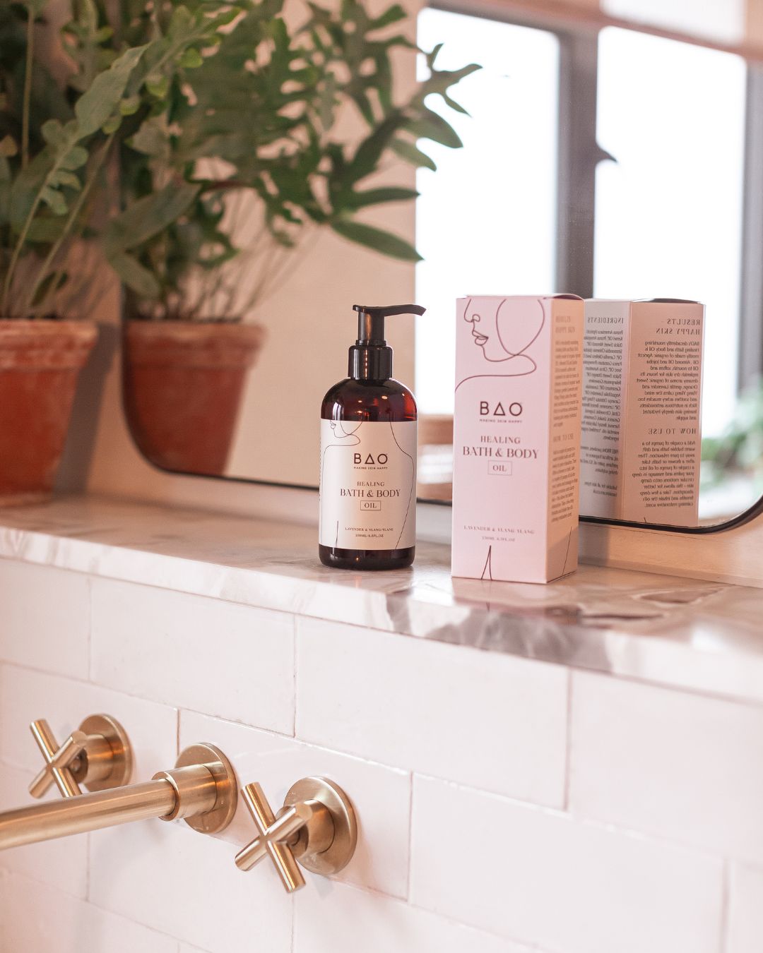 BAO Healing Bath & Body Oil bottle and its packaging box displayed on a marble bathroom shelf