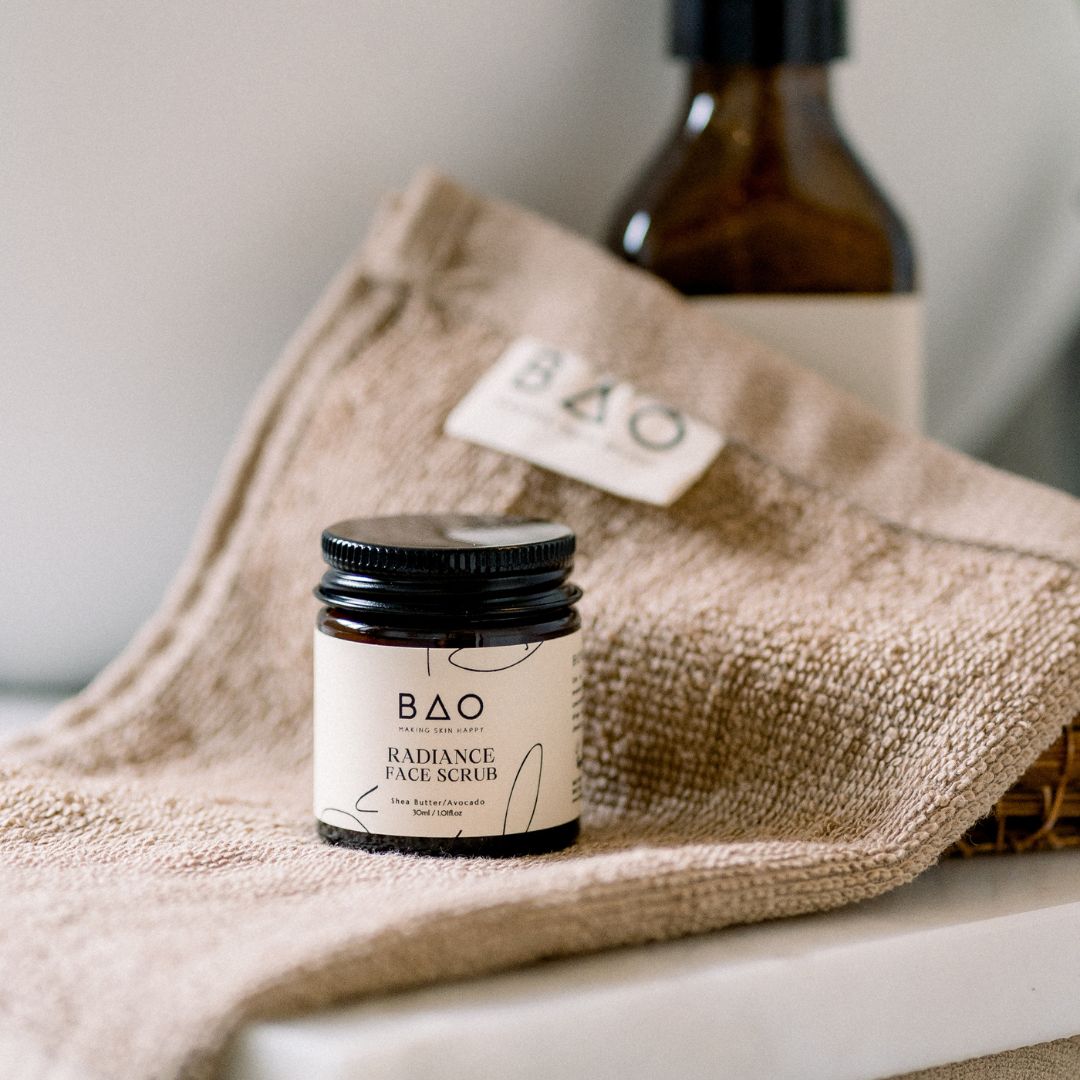 BAO Radiance Face Scrub jar displayed on a folded towel with a BAO tag