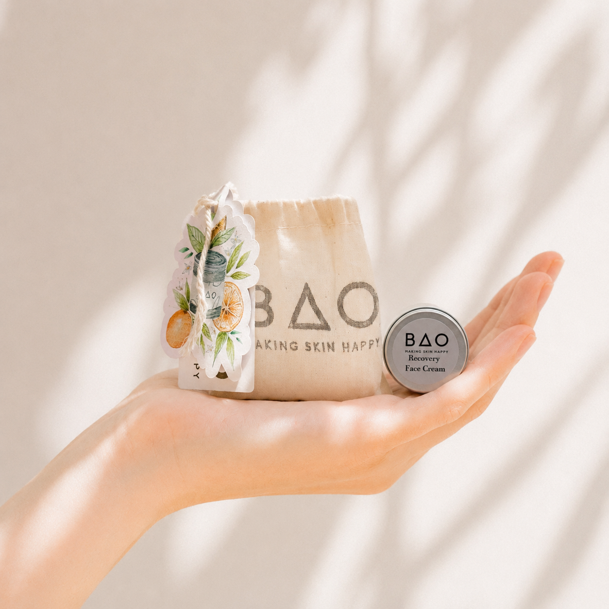 Hand holding BAO skincare products against a neutral background