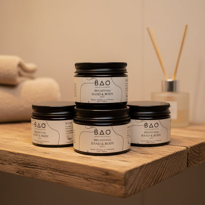 Three jars of BAO Bright &amp; Body product on a textured surface with a window in the background.
