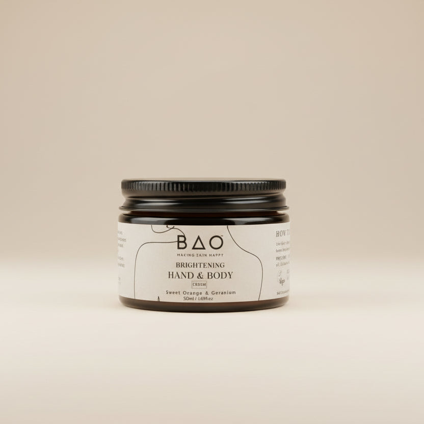 Jar of BAO hand and body cream on a textured surface with a blurred background