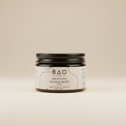 Jar of BAO hand and body cream on a textured surface with a blurred background