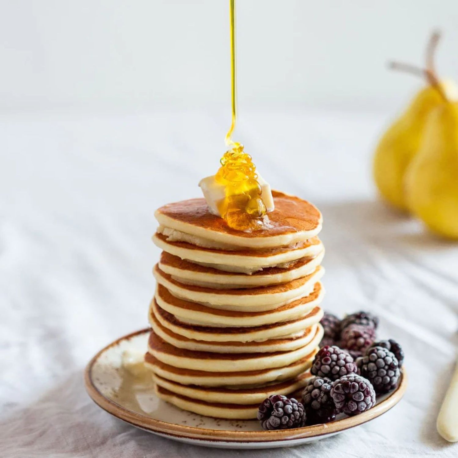Healthy stack of pancakes on a plate with organic blackberries