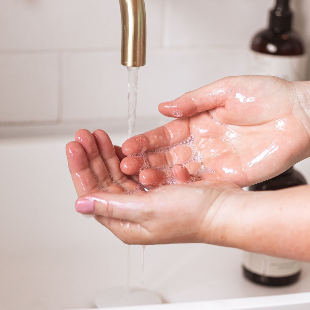Hands lathering BAO Brightening Hand &amp; Body Wash under running water
