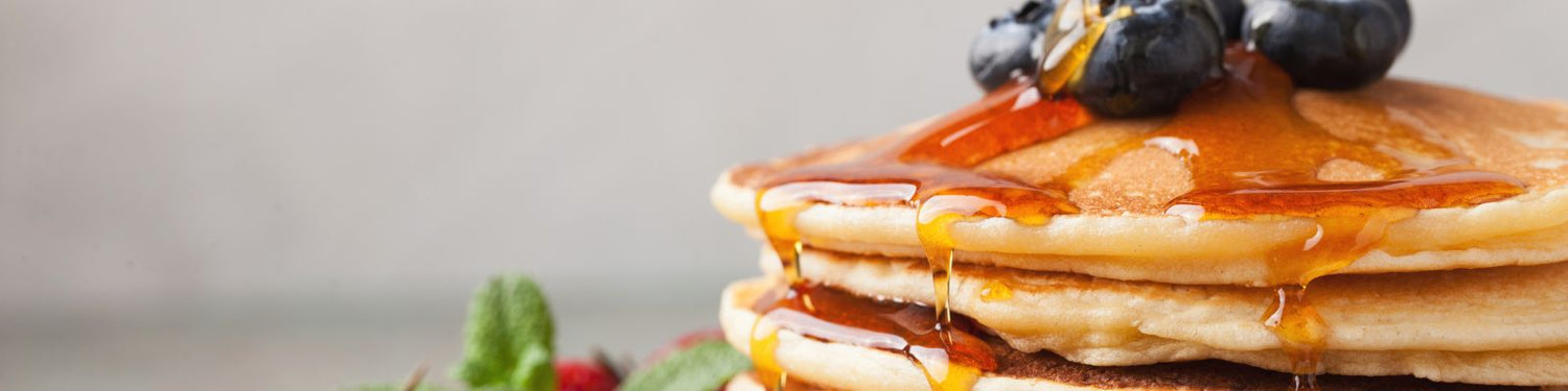 Stack of pancakes drizzled with maple syrup and fresh berries