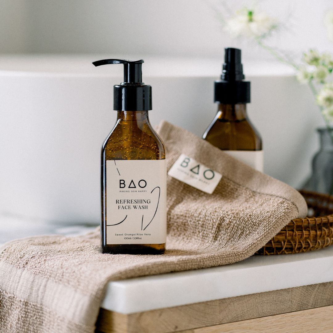 BAO Refreshing Face Wash bottle displayed on a folded towel beside a bathtub