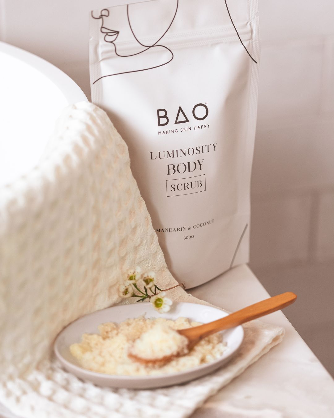 BAO Luminosity Body Scrub pouch beside a Brightening Hand &amp; Body Wash bottle