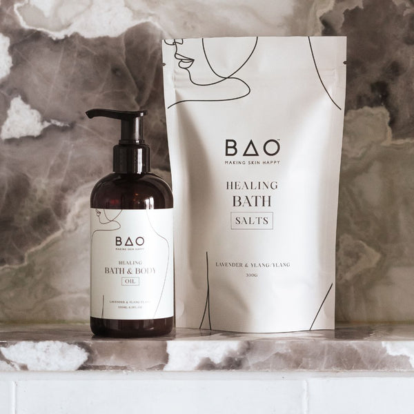 BAO Healing Bath Salts and Bath & Body Oil on a marble surface with a marble background