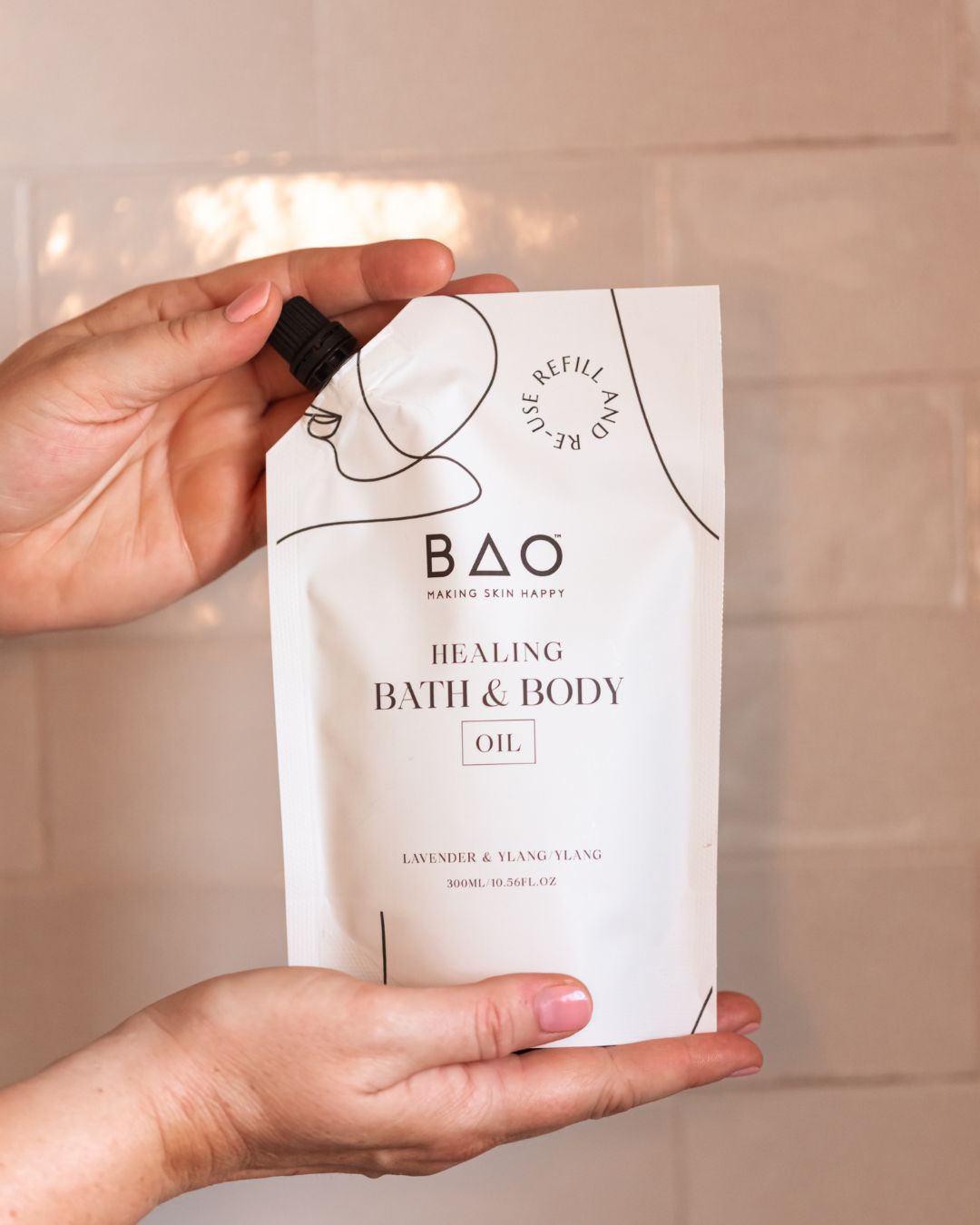 Hand holding BAO Healing Bath &amp; Body Oil refill pouch